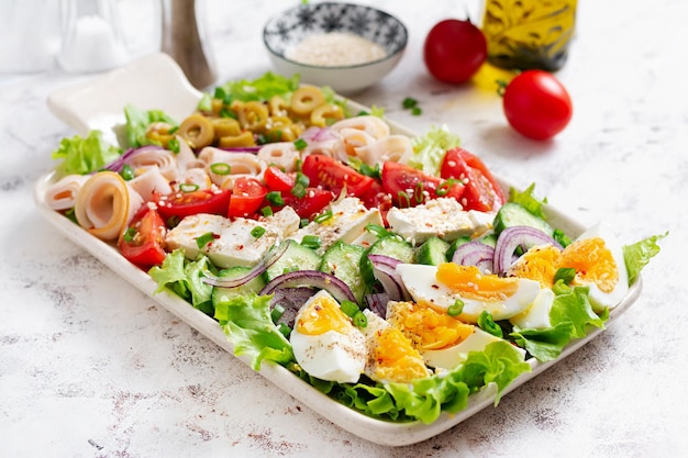 Healthy cobb salad with ham cucumber tomato olives feta cheese and eggs Ketogenic lunch