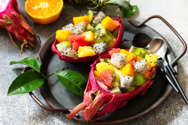 Healthy diet detox fruit salad in summer in a bowl of dragon fruit on a stone blue countertop