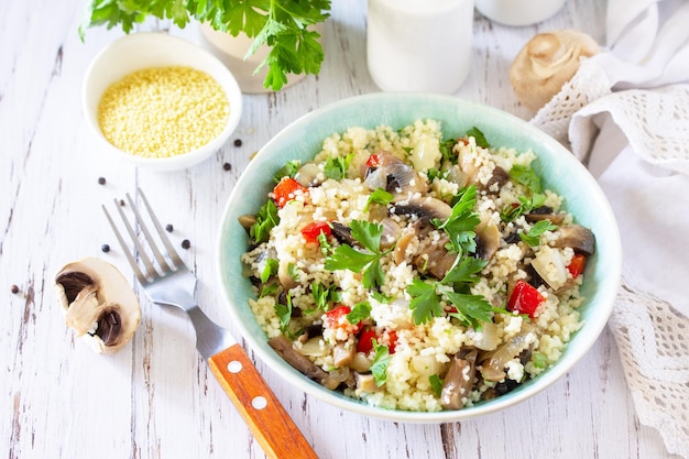 Healthy diet food Vegan salad with couscous and champignons on a wooden kitchen table