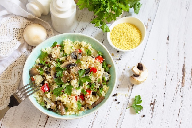 Healthy diet food Vegan salad with couscous and champignons on a wooden kitchen table