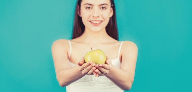 Healthy diet food Woman with perfect smile holding apple blue background