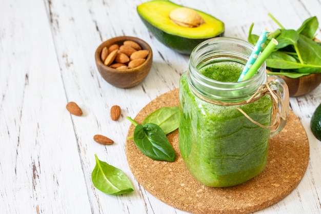 Healthy diet and nutrition vegan Green smoothie with spinach avocado and almond nuts Copy space