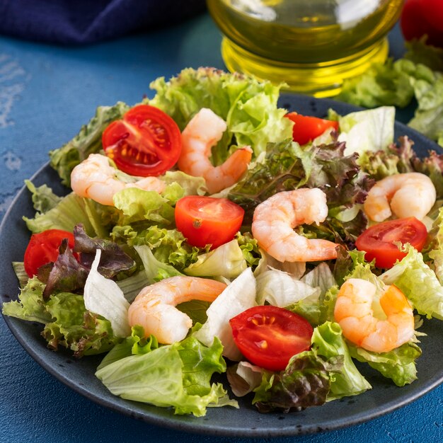 Healthy and diet salad with shrimps, tomatoes and mixed greens.