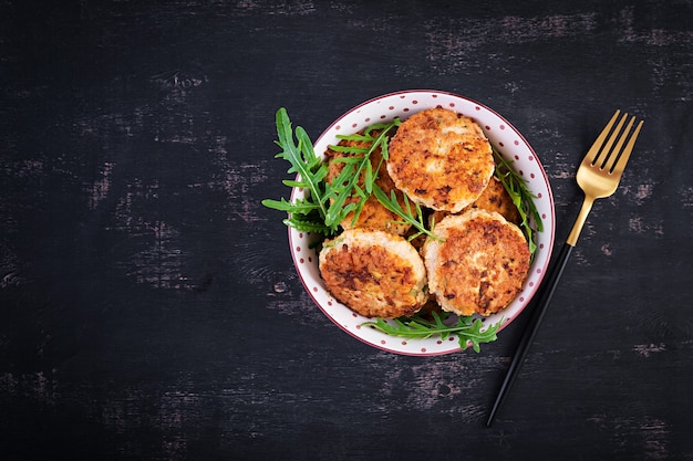 Healthy dinner. Chicken cutlets in a bowl on a dark background. Top view, flat lay