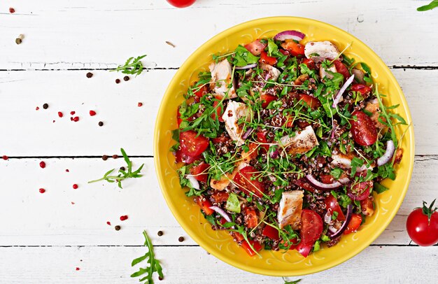 Healthy dinner.  Salad bowl lunch with grilled chicken and quinoa, tomato, sweet peppers, red onions and arugula Flat lay. Top view