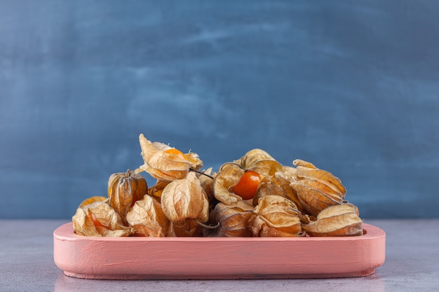 Healthy dried cumquats placed on a pink board . 