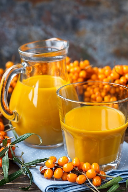 Healthy drink with sea buckthorn and rough board. Selective focus