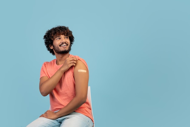 Healthy eastern man with medical plaster on his shoulder