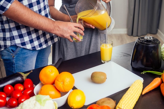 Healthy and eco lifestylehappy indian woman with her husband making smoothie in big kitchen