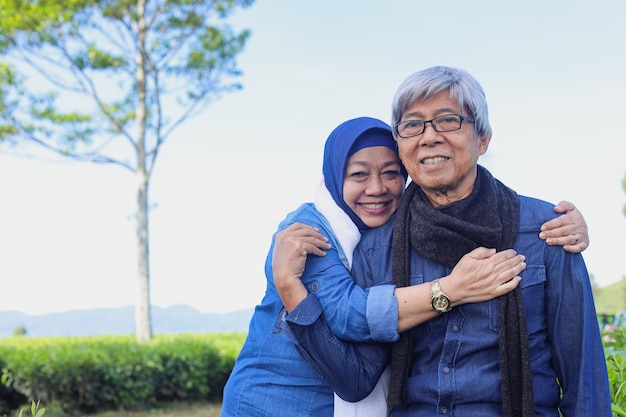 Healthy elderly couple Joyful senior romantic couple smiling to the camera at tea plantation