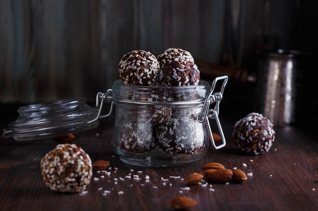 Healthy energy granola bites with nuts, dates, honey and sesame in a glass jar