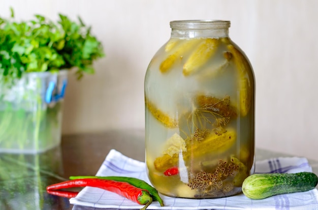 Healthy fermented food Salt cucumbers in a glass jar with dill and peppers on the kitchen table