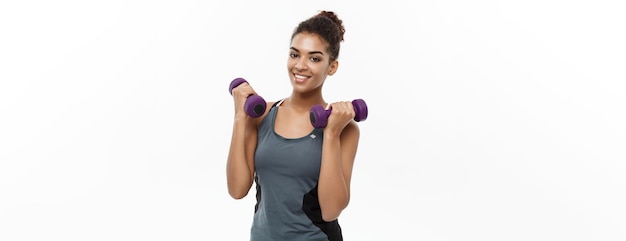 Healthy and Fitness concept Beautiful American African lady in fitness clothes workout with dumbbell Isolated on white background