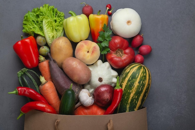 Healthy food background Healthy vegan vegetarian food in paper bag vegetables and fruits on gray copy space banner Shopping food supermarket and clean vegan eating concept