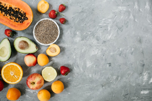 Healthy food clean eating selection: fruit, berries, Chia seeds, superfood on gray concrete background.Top view, flat lay. High quality photo