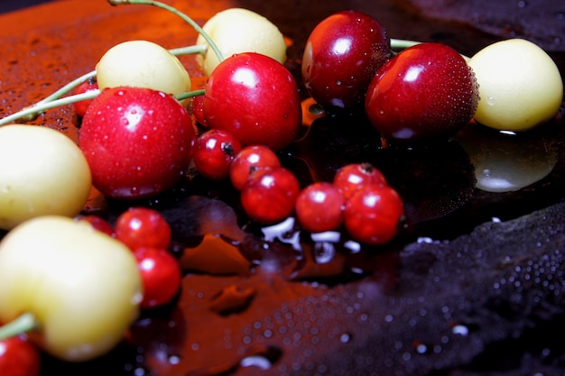 Healthy food concept Closeup of sweet berries with drops of water on a black background View from above