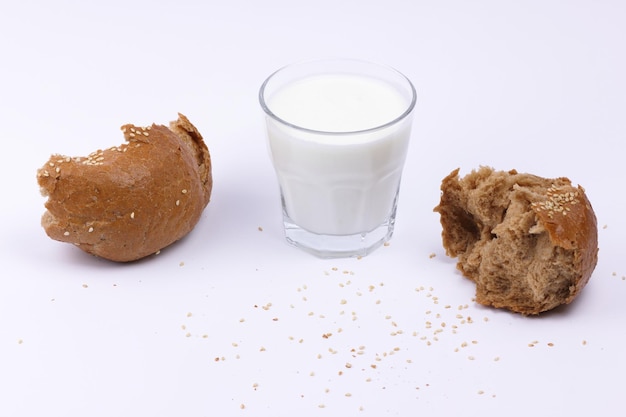 Healthy food concept Full transparent glass of white milk with slices of rye bun isolated on white background Food for a healthy snack