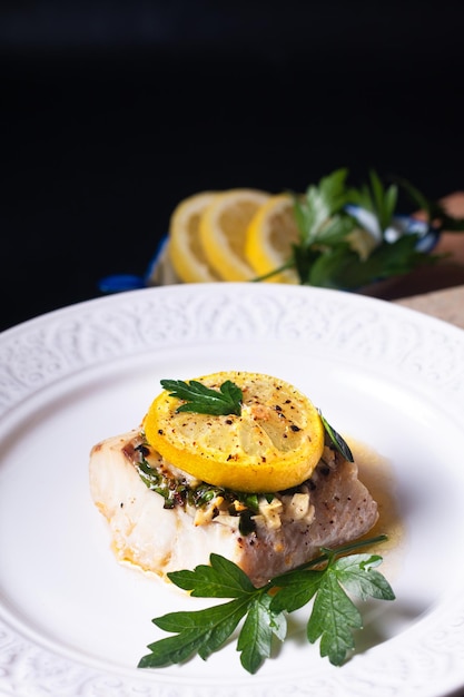 Healthy Food concept Homemade Lemon garlic butter Baked Cod fish on black background with copy space