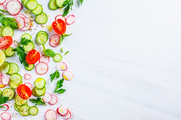 Healthy food concept. Slices of tomato, radish and cucumber on white background, top view, copy space.