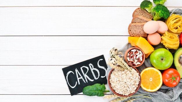 Healthy food containing carbohydrates bread pasta avocados flour pumpkin broccoli beans spinach On a white background Top view Free copy space