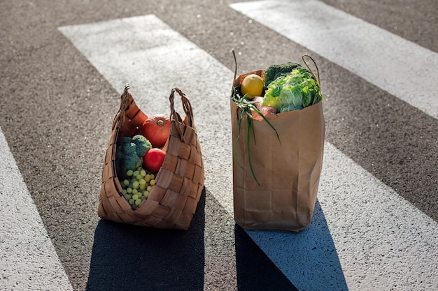 Healthy food groceries in eco friendly shopping bags stands on a crosswalk