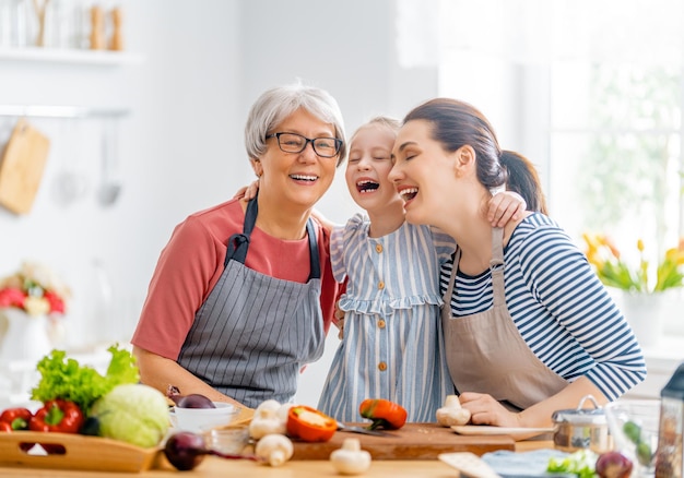 Healthy food at home Happy family in the kitchen Grandma mother and child daughter are vegetables