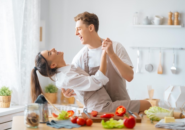 Healthy food at home Happy loving couple is preparing the proper meal in the kitchen