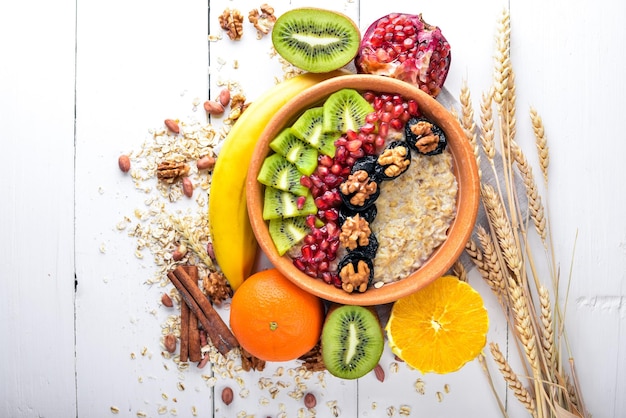 Healthy food porridge with fruit kiwi banana and nuts On Wooden background Top view