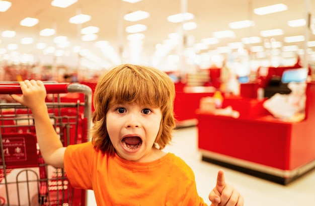 Healthy food for young family with kids boy at grocery store or supermarket portrait of funny little