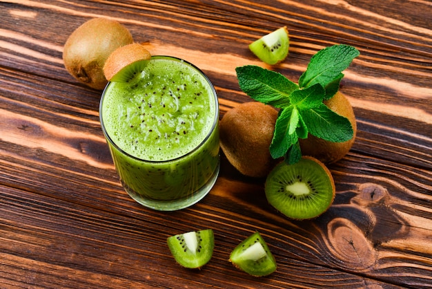 Healthy fresh kiwi smoothie in glass on a wooden table