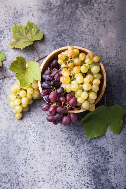 Photo healthy fruits red and white wine grapes on stone surface s