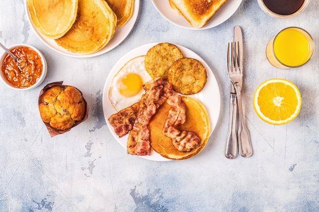 Healthy Full American Breakfast with Eggs Bacon Pancakes and Latkes, top view.