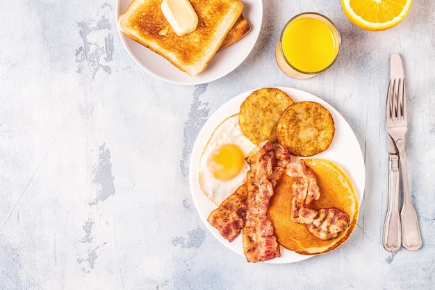 Healthy Full American Breakfast with Eggs Bacon Pancakes and Latkes, top view.