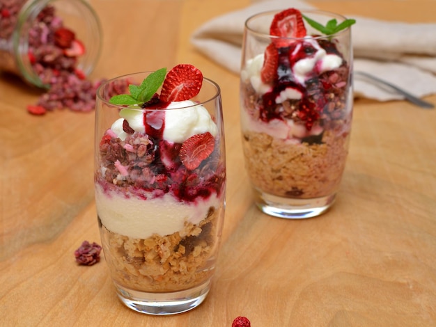 Healthy granola snack with natural yogurt and berries in glasses