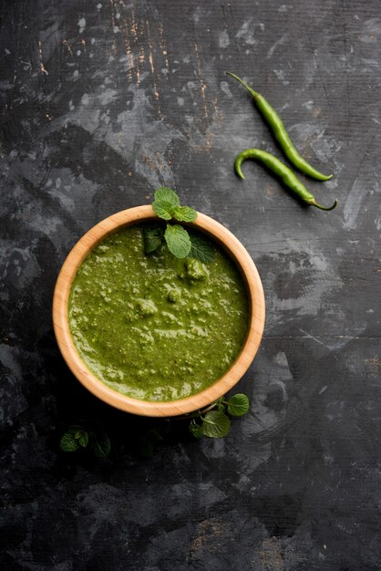 Photo healthy green mint chutney made with coriander, pudina and spices. isolated moody background. selective focus