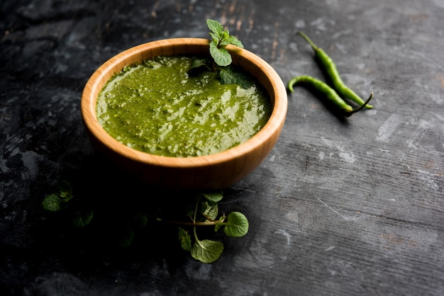 Healthy Green Mint Chutney Made with Coriander, pudina And Spices. isolated moody background. selective focus