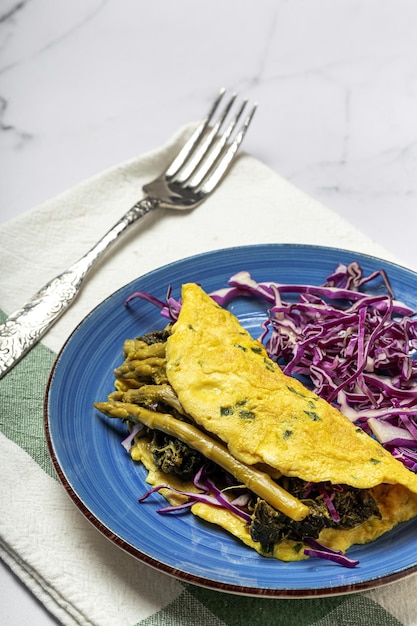 Healthy Homemade Green Asparagus Omelette with Spinach and Purple Cabbage with copy space. Vegan food concept