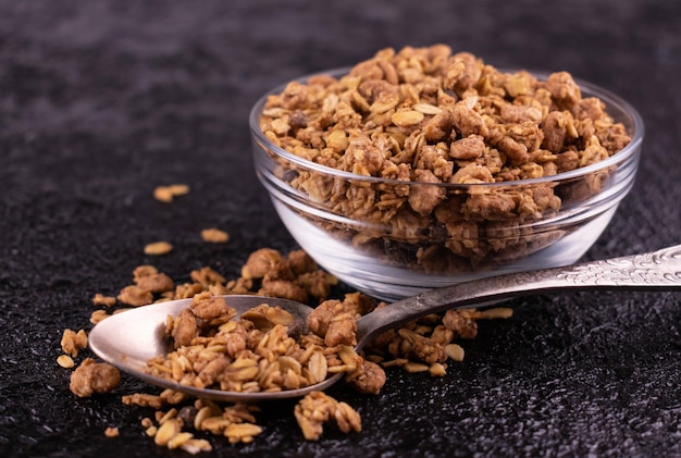 Healthy homemade muesli in a glass bowl on a black background