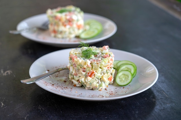 Healthy homemade russian traditional salad olivier ready to eat in plate, close up