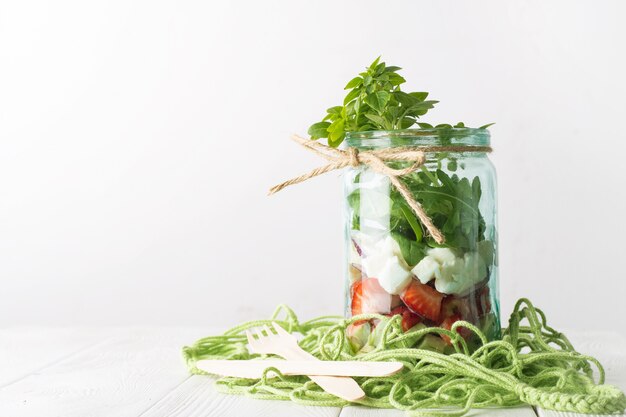 Healthy homemade salad with fresh products and herbs in glass jar