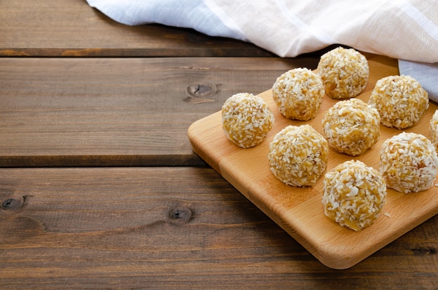 Healthy homemade sweet energy balls of dried fruits and nuts in coconut. The composition of dried apricots, raisins, figs, dates, almonds, walnuts, hazelnuts, honey.