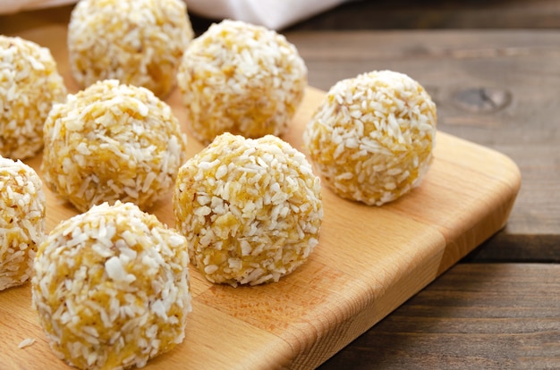 Healthy homemade sweet energy balls of dried fruits and nuts in coconut.