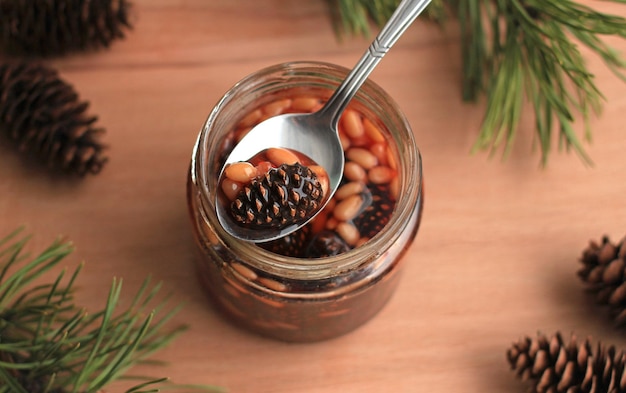 Healthy jam from pine cones with pine nuts on a beige background