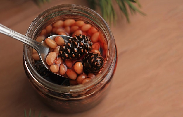 Healthy jam from pine cones with pine nuts on a beige background