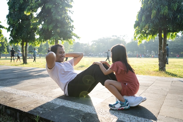 Healthy lifestyle of family with child dad sit up and child sitting on the feet