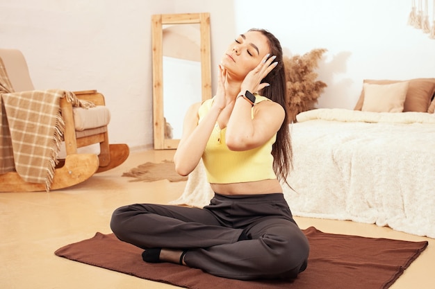 A healthy lifestyle. A woman does yoga, sits in a lotus position. mat, exercise Facial massage