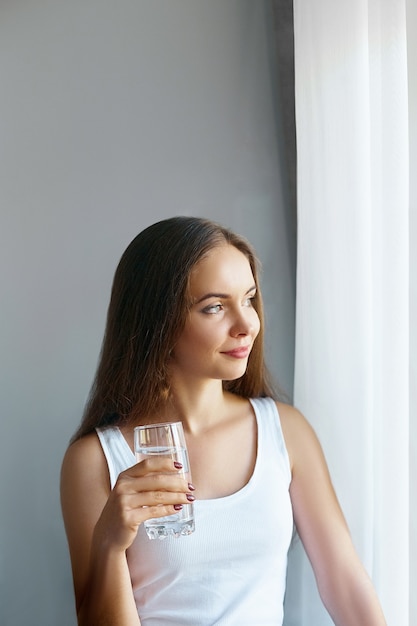 Healthy lifestyle.Young woman drinking from a glass of fresh water