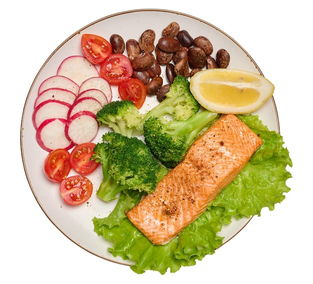 Healthy lunch with grilled trout on green lettuce next to vegetables tomatoes radishes broccoli