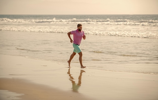 Healthy man running on beach energetic summer runner feel freedom enjoying the morning