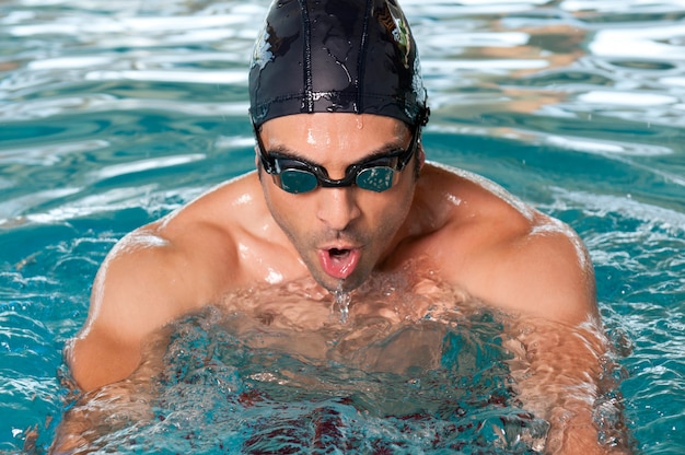 Healthy man swimming with effort at swimmingpool